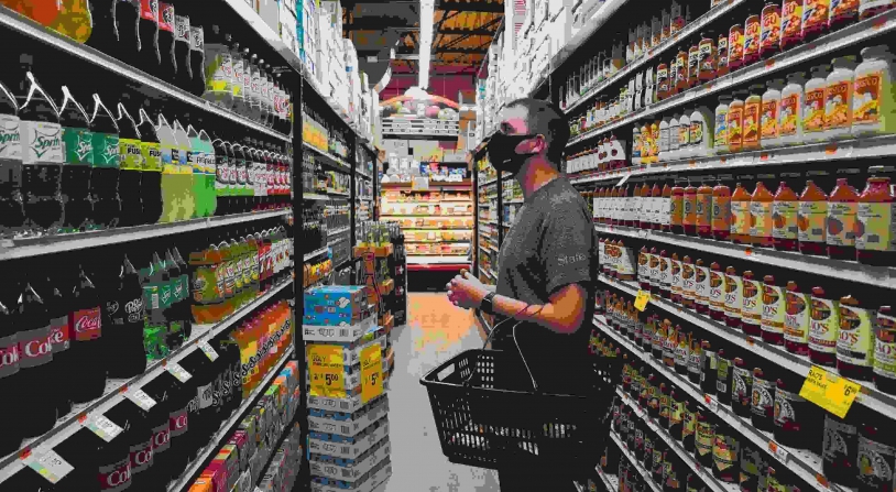 man looking at beverages in a grocery aisle